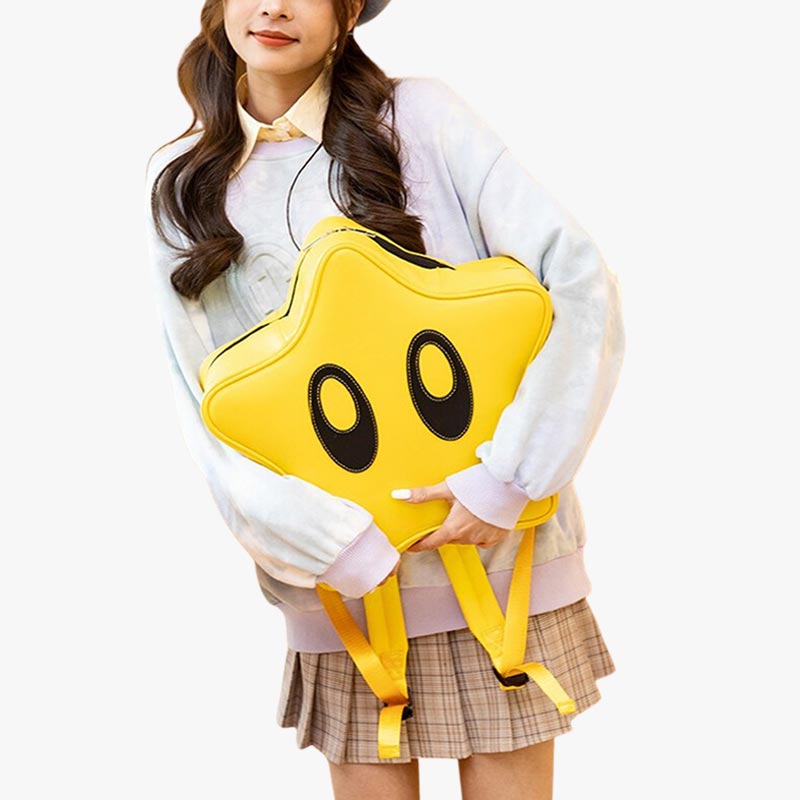Una mujer sostiene una mochila amarilla con forma de estrella kawaii. Bonita mochila japonesa para outfits de Harajuku.