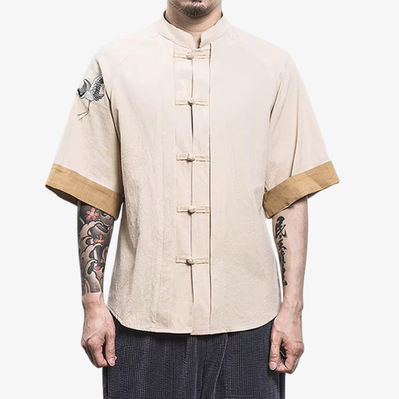 Hombre con camisa tsuru bordada con grullas sobre algodón color crema, símbolo de longevidad y paz