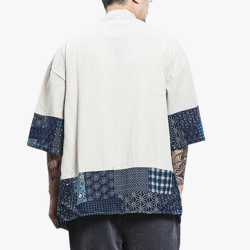 Un hombre lleva un cárdigan estilo kimono japonés corto. La chaqueta haori es blanca y los extremos de la tela están decorados con motivos geométricos japoneses.