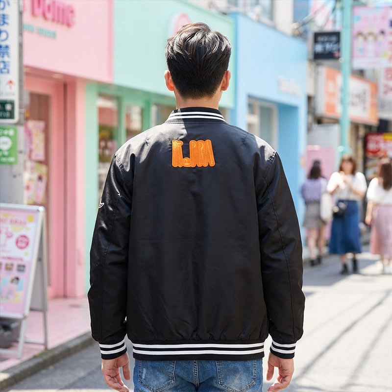 Persona con una chaqueta bomber negra en una calle de Harajuku