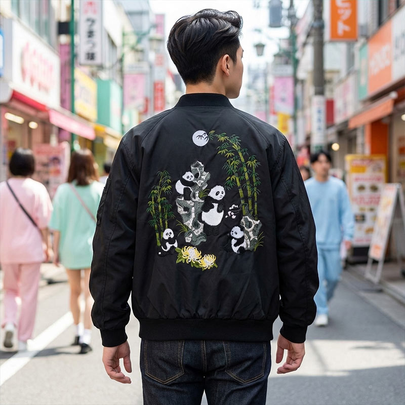 Persona luciendo una chaqueta bomber sukajan negra con motivos de panda en la ciudad