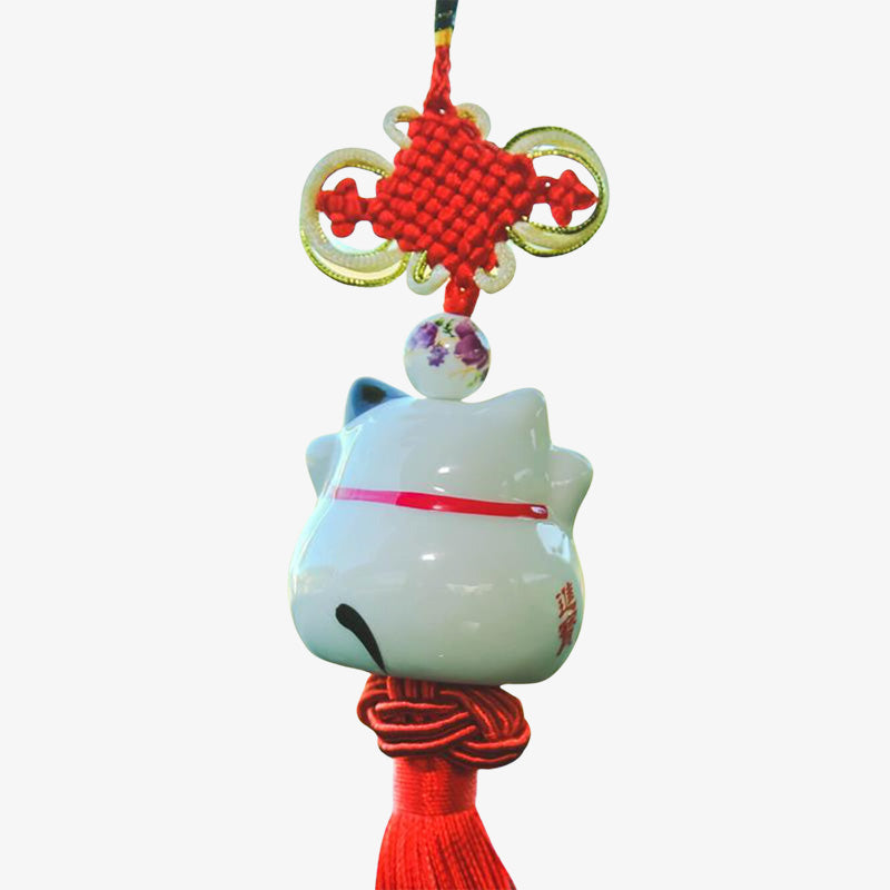 Decoración japonesa de gato blanco colgada del retrovisor de un coche