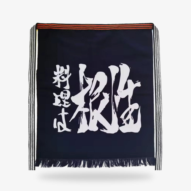 Delantal japonés maekake tradicional en algodón grueso azul marino con un llamativo kanji blanco, que combina diseño funcional y profundo significado cultural para un uso en la cocina.