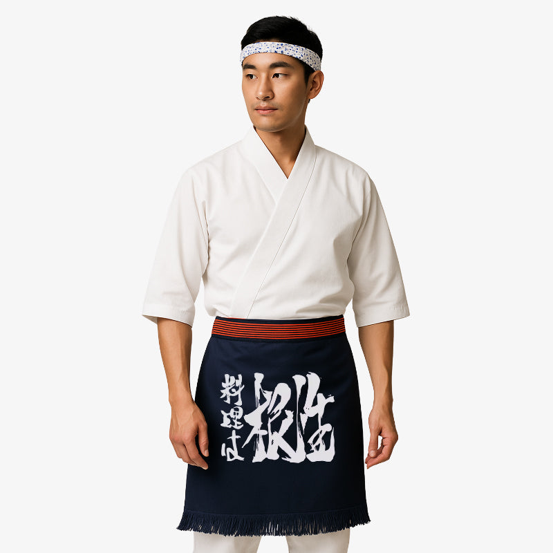 Delantal japonés maekake de algodón grueso azul marino con estampado kanji blanco, símbolo de autenticidad y herencia cultural en las artes culinarias.