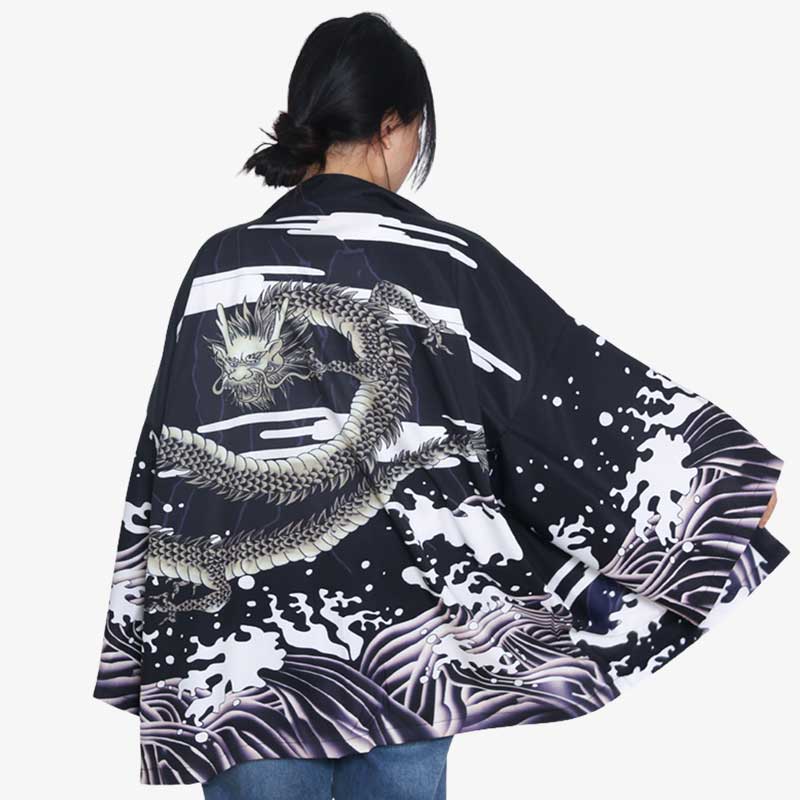 Kimono mujer dragón negro con estampado de olas japonesas, mujer de pie luciendo la chaqueta