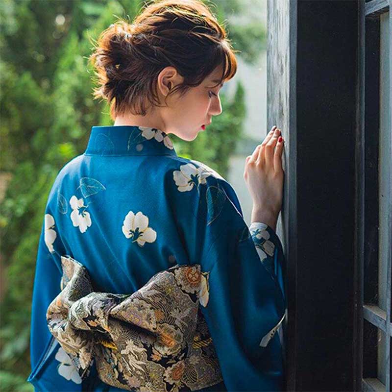 Kimono obi japonés combinado con un cinturón sobre un vestido floral