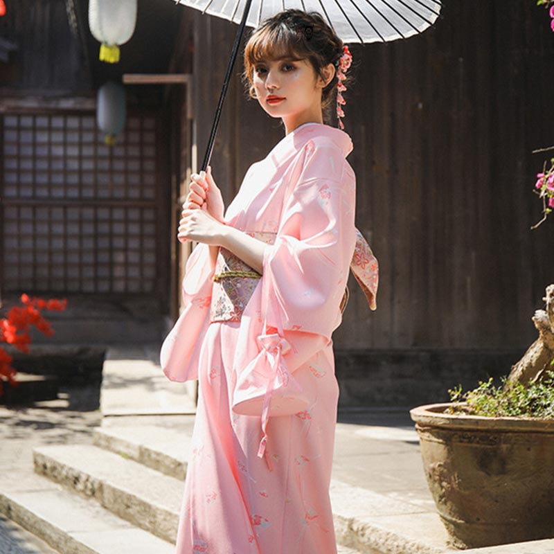 Mujer con kimono tradicional japonés y obi sakura geisha en la cintura, sombrilla japonesa y kanzashi en el cabello