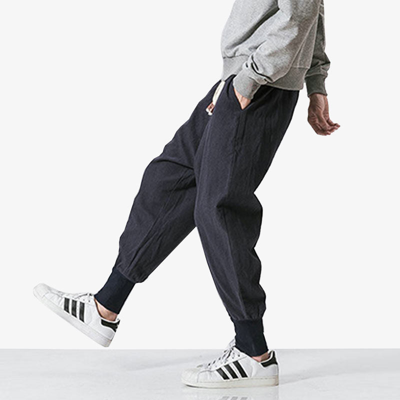 Hombre con pantalones anchos de estilo japonés y zapatillas blancas