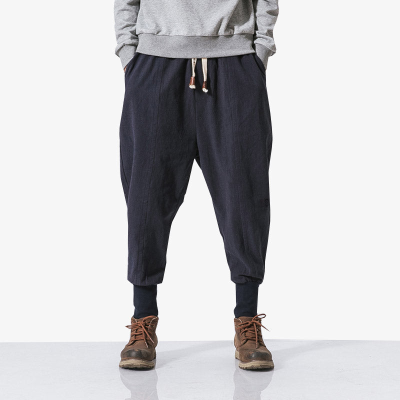Hombre vistiendo pantalones streetwear japoneses con sudadera gris y botines
