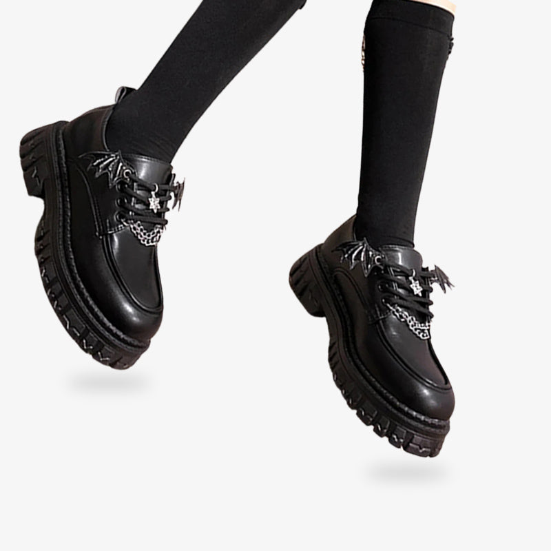 Calzado negro con acabados adorables, ofreciendo un look divertido influenciado por las tendencias góticas Lolita japonesas