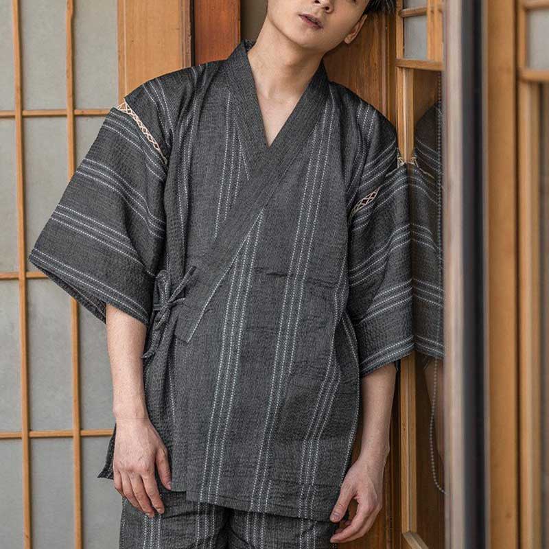 Un hombre vestido con Jinbei Ropa Kimono Japones. Este conjunto japonés se compone de una camisa kimono tradicional y unos pantalones cortos confeccionados en lino y algodón.