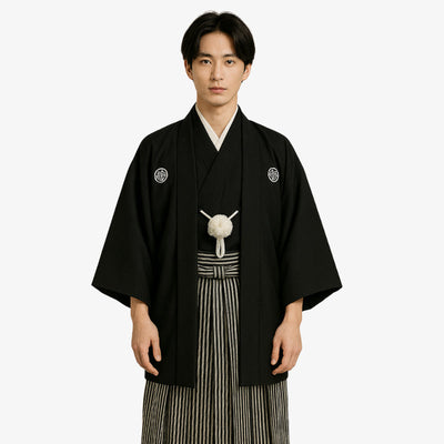 Kimono hombre tradicional japonés negro con escudos familiares tradicionales, combinado con una chaqueta haori clásica y pantalones hakama a rayas, confeccionado con auténticos tejidos Habutae y Sendaihira.
