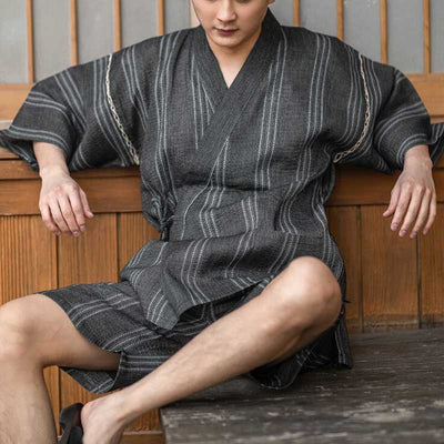 Un hombre viste una pijama jinbei ropa japonesa para hombre confeccionada con lino y algodón. El color del kimono japonés de verano es gris.