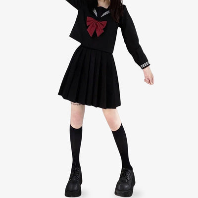 Para un disfraz de cosplay, ponte un uniforme Sailor Fuku Cosplay de colegio para chicas. La mujer lleva una camisa negra, calcetines largos japoneses y una camisa negra.