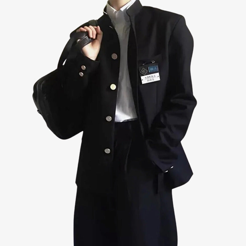 Una persona de pie viste un Uniforme Japones Hombre negro. También lleva una camisa blanca.