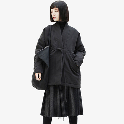 Chica vestida con un abrigo kimono negro de algodón grueso y cinturón a la cintura