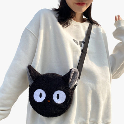 Mujer llevando un bolso kawaii de gato negro con ojos grandes al hombro