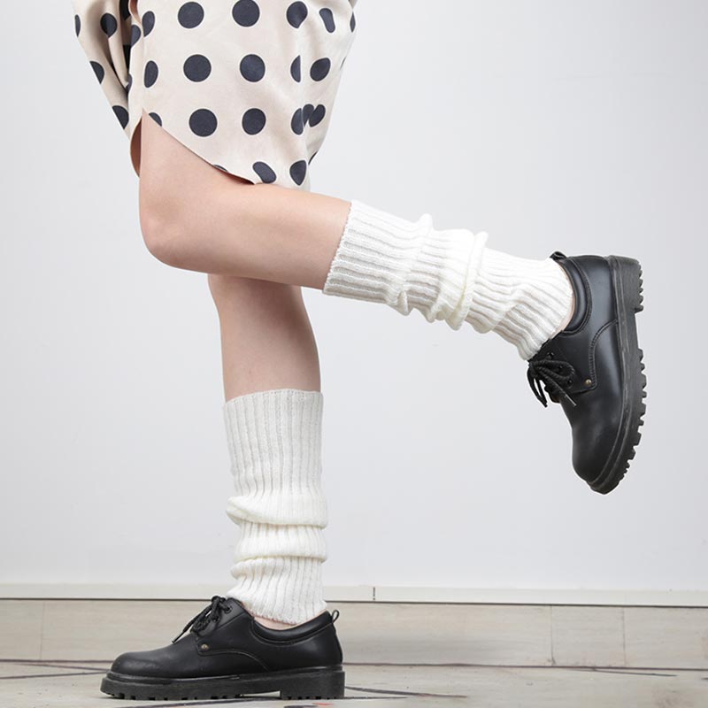 Una chica viste una falda lolita y calcetines japonese kawaii largos. El material es algodón y el color de los calcetines japoneses es blanco. La chica japonesa lleva zapatos negros de estudiante en los pies.