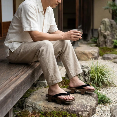 Sandalias geta llevadas con calcetines tabi blancos en un jardín japonés