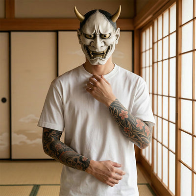 Persona con máscara tradicional japonesa sobre suelo de tatami y camiseta blanca japonesa