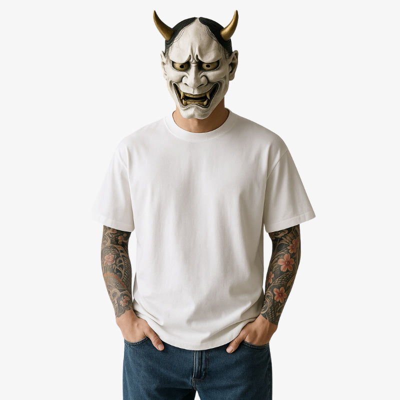Hombre con camiseta blanca Harajuku Lovers, rostro cubierto por una máscara hannya y tatuajes irezumi en los brazos