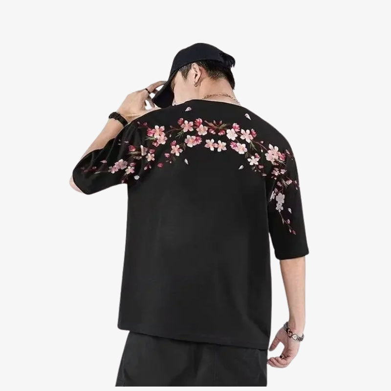 Persona con camiseta sakura negra humbre con flores rosas sobre fondo blanco