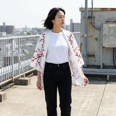 Cárdigan japonés floral blanco abierto sobre una terraza, combinado con vaqueros negros