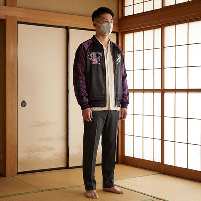 Hombre con chaqueta bomber morada y estampado floral en una sala tradicional japonesa