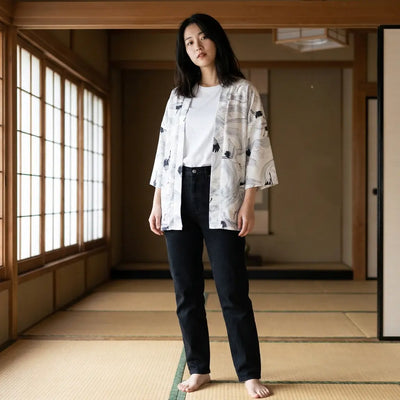 Mujer luciendo un haori blanco en una sala con tatami y paneles shoji