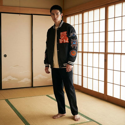 Hombre con una chaqueta sukajan negra con parches de colores en una habitación tradicional japonesa