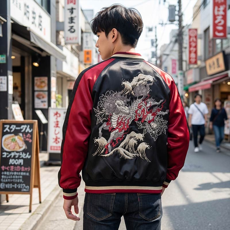 Persona con una chaqueta sukajan negra y roja bordada con un diseño de Kirin en una calle de la ciudad