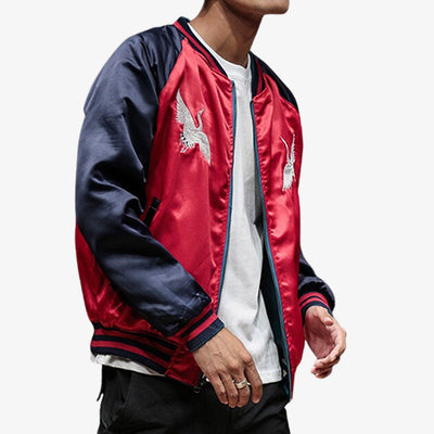 Un hombre lleva una chaqueta sukajan japonesa reversible de raso en color rojo, con bordados que evocan la rica herencia de Japón