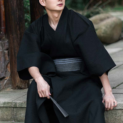 Hombre vestido con kimono negro y cinturón obi gris de algodón