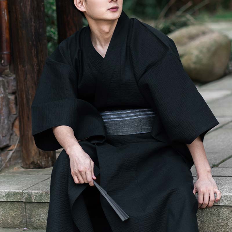 Hombre vestido con kimono negro y cinturón obi gris de algodón