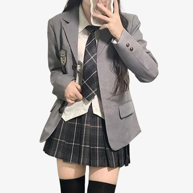 Una chica vestida con un cosplay uniforme escolar japones. Chaqueta japonesa gris, con una camisa de cuadros de estudiante, una camisa blanca y una falda con corbata.