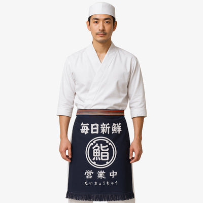 Delantal japonés tradicional en algodón azul marino con kanji blanco en gran tamaño, ideal para chefs y aficionados a la cocina japonesa