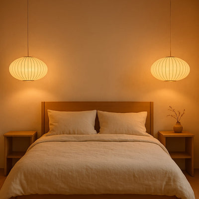 Dormitorio con cabecero de madera, ropa de cama beige y dos lámparas japonesas modernas colgantes que emiten un cálido resplandor