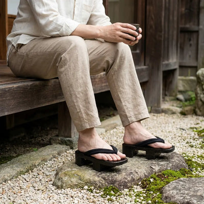 Sandalias geta llevadas con calcetines tabi blancos en un jardín japonés