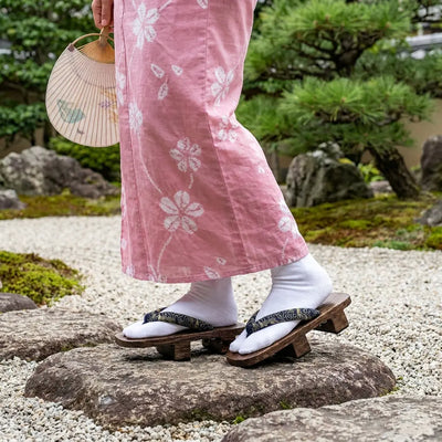 Geta llevadas con un kimono rosa en un jardín japonés