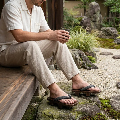 Geta con motivo seigaiha llevada sentado por un hombre en un jardín japonés