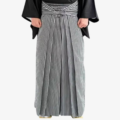 Hakama kimono con pantalón plisado de pernera ancha y parte superior de kimono clásico, reflejo de la herencia cultural japonesa, con rayas negras