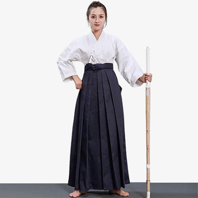 Una artista marcial japonesa vestida con hakama mujer, un keikogi blanco y sosteniendo un shinai de madera