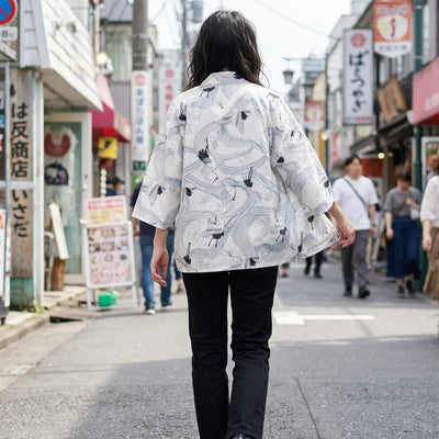 Mujer vista de espaldas luciendo un haori blanco en una calle de Harajuku