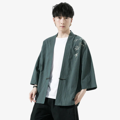 Persona con una chaqueta tipo kimono Haori verde con bordados blancos sobre fondo blanco