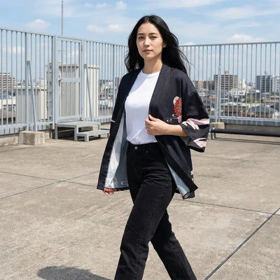 Haori negro con arte japonés llevado abierto sobre una camiseta blanca en una azotea urbana