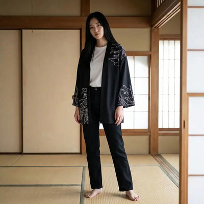 Haori oni mujer negro con estampado de máscara demoníaca roja, llevado abierto en una sala de tatami