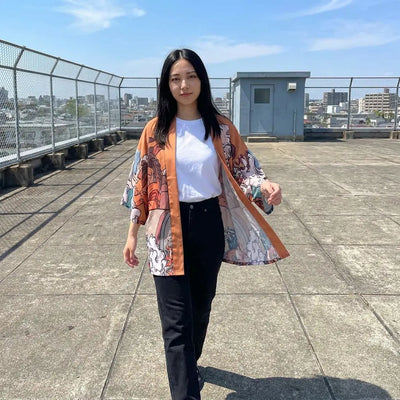 Haori ukiyo-e para mujer en tonos naranja y azul, llevado en una azotea urbana