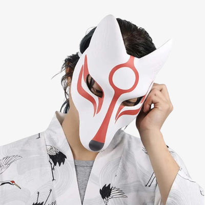 Un hombre lleva una máscara facial okami inspirada en el símbolo japonés de la diosa Amaterasu, junto con un kimono blanco