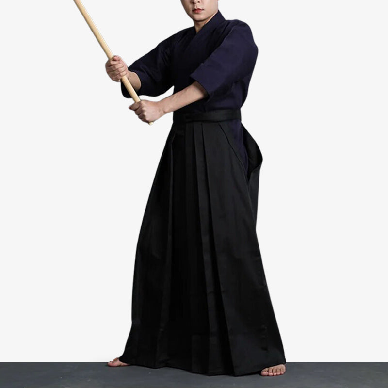 Hombre vestido con hakama negro sujetando una katana de madera