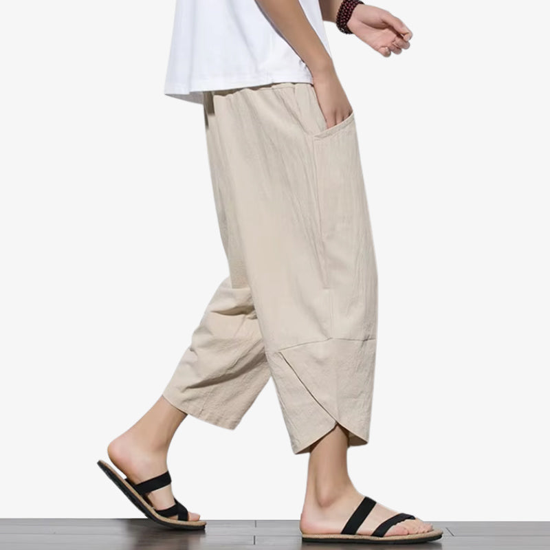 Hombre vistiendo un pantalón japonés cropped beige minimalista con sandalias negras